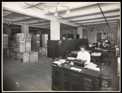 View of men and women at desks in what appears to be a shipping room at Parke, Davis and Co., chemists, Hudson and Vestry Streets, New York, 1910 by Byron Company